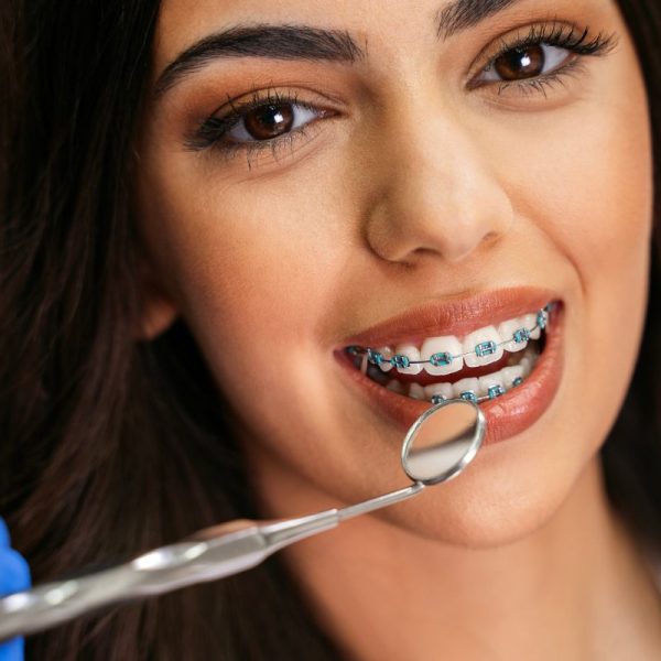 Orthodontist examining patient’s braces