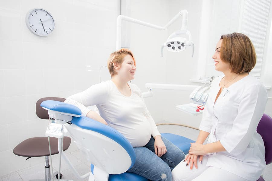 pregnant woman discussing braces with an orthodontist